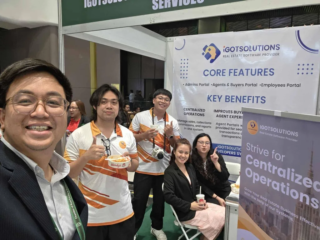 iGotSolutions team members gathered at the company's CREBA 2025 exhibit booth, in front of banners listing the Admins, Agents and Buyers, and Employees portals.